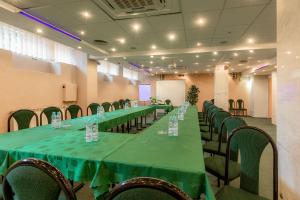 a long table in a room with green tables and chairs at Halny Pensjonat in Zakopane