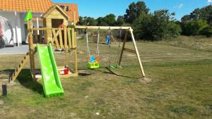 um parque infantil com dois baloiços num quintal em Villa Silbermöwe em Trent