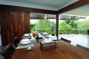 a dining room with a table and a large window at Koh Yao Sunrise Villa in Ko Yao Noi
