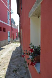 um edifício vermelho com um vaso de plantas numa janela em Il Posto dell’Origano em La Spezia