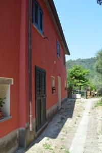 un edificio rojo con una puerta en una calle en Il Posto dell’Origano, en La Spezia