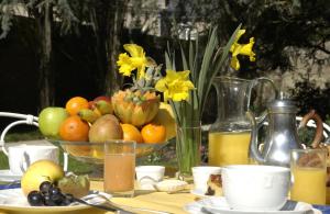 een tafel met een fruitschaal en een vaas met bloemen bij Malouinière Le Valmarin in Saint-Malo
