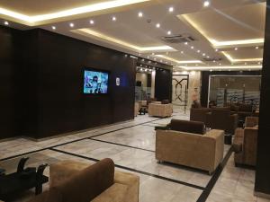 a lobby with couches and a tv on a wall at Saad Palace Residential Units - Al Rabwa 2 in Abha