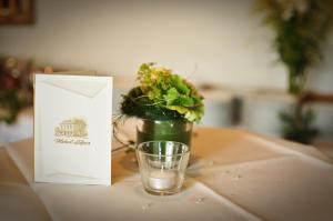 un vaso de agua sentado junto a una planta en una mesa en Hotel Litjes, en Goch