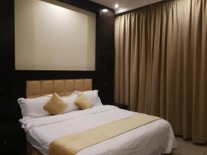 a bedroom with a large bed with white sheets and pillows at Saad Palace Residential Units - Al Rabwa 2 in Abha