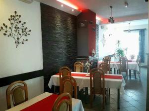 a restaurant with tables and chairs and a brick wall at Pensiunea Evelyn in Gîrleni