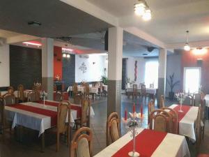 een eetkamer met tafels en stoelen in een restaurant bij Pensiunea Evelyn in Gîrleni