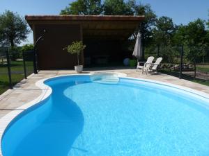 a large blue swimming pool in a backyard at Logis de La Bénétière in Treize-Vents