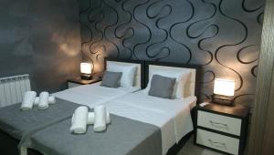 a bedroom with a bed with white sheets and two lamps at Metekhi Vista in Tbilisi City