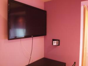 ブルゴスにあるJimena Parejasのピンクの壁に掛けられた薄型テレビ