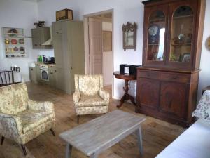 a living room with a table and two chairs and a cabinet at En Patmo Holiday Home in Patmos