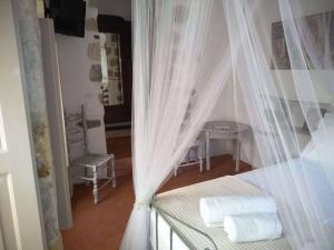 a bedroom with a bed with curtains and a table at En Patmo Holiday Home in Patmos