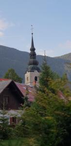a church with a steeple on top of a building at Apartment Alpska Astra in Kranjska Gora