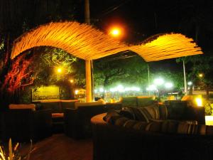 a restaurant with couches and lights at night at Hotel Itapemar - Ilhabela in Ilhabela