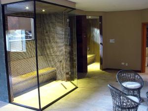 a room with a cage with a bench and a chair at Hotel Itapemar - Ilhabela in Ilhabela