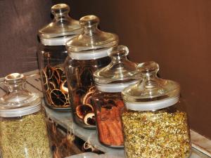 a group of glass jars filled with different spices at Hotel Itapemar - Ilhabela in Ilhabela