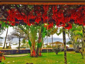 a bunch of red flowers hanging from a ceiling at Hotel Itapemar - Ilhabela in Ilhabela