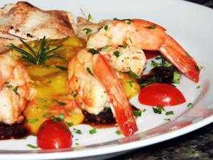 a plate of food with shrimp and vegetables on a table at Hotel Itapemar - Ilhabela in Ilhabela