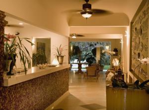 a lobby of a house with a mirror and plants at Hotel Itapemar - Ilhabela in Ilhabela