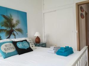 - un lit blanc avec des oreillers bleus dans l'établissement Gui Beach House, à Armação de Pêra