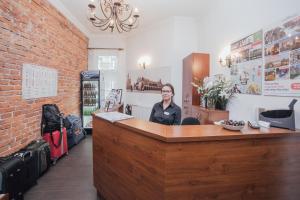 a woman is sitting at a counter in a room at Apartamenty Bonerowska 5 in Krakow