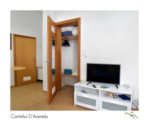 a living room with a television and a white cabinet at Cantinho D'Avenida in Velas