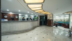 a lobby with a bar with two people standing at a counter at Hotel Century Reforma in Mexico City