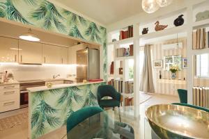 una cocina con encimera con sillas verdes. en Luxurious triplex near the beach In Estoril, en Estoril