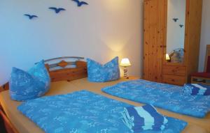 a bedroom with two beds with blue sheets and birds on the wall at Ferienwohnung Möwe in Graal-Müritz