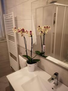 een badkamer met een wastafel met een vaas met bloemen erop bij Nonna Rosa House in Scala