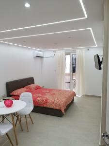 1 dormitorio con cama roja, mesa y mesa en Apartments Vida, en Budva