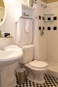 a white bathroom with a toilet and a sink at The Marshall House, Historic Inns of Savannah Collection in Savannah