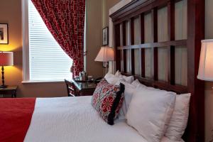 a bedroom with a large bed with white pillows at The Marshall House, Historic Inns of Savannah Collection in Savannah