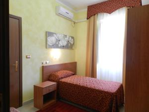 a small bedroom with a bed and a window at Hotel Air Palace Lingotto in Turin