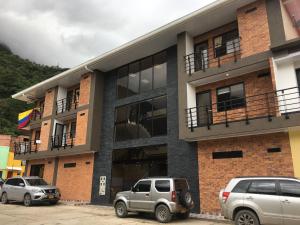 two cars parked in front of a building at Hotel el peñón in Santa María