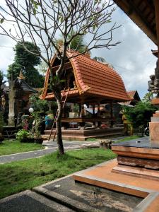 um pavilhão com uma árvore num parque em Pica Sedana Homestay em Ubud