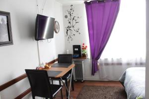 a bedroom with a desk and a bed with purple curtains at Gloria in Santiago