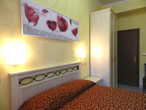 a hotel room with a bed and a painting on the wall at Hotel Air Palace Lingotto in Turin