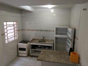 a small kitchen with a stove and a refrigerator at Edificio Netuno in Cabo Frio