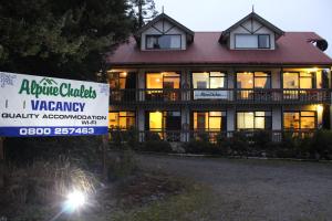 a large house with a sign in front of it at Alpine Chalets in National Park