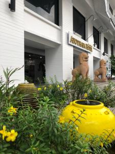 a large yellow vase in front of a building at Sunday Ayothaya Hotel in Phra Nakhon Si Ayutthaya