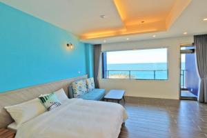 um quarto de hotel com uma cama e uma grande janela em Two Home Inn em Hualien City