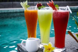 tre drink seduti su un tavolo accanto alla piscina di Zuri Express Jimbaran a Jimbaran