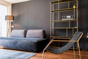 a living room with a blue couch and a chair at Stay COOPER l MAVIK in Bolzano