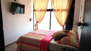מיטה או מיטות בחדר ב-Apartasuites Medellin Los Molinos