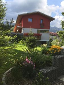 czerwony dom z ogrodem przed nim w obiekcie Vila Anna w mieście Dolný Smokovec