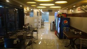 a restaurant with tables and chairs and a video game at Hotel Gujrat in Nagpur