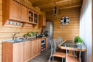 a kitchen with wooden cabinets and a table with chairs at Domik u morya in Gribovka