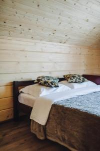 two beds in a room with a wooden wall at Domik u morya in Gribovka