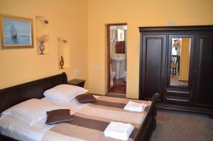 a bedroom with two beds and a bathroom at Pensiunea Koruna in Poenari